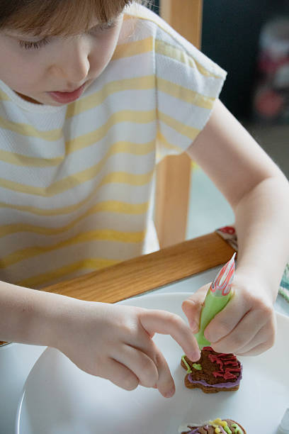 istock Girl decorating a gingerbread cookies 2250706778
