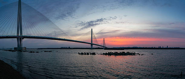 istock Sunset view of a modern cable-stayed bridge over water 2250707436