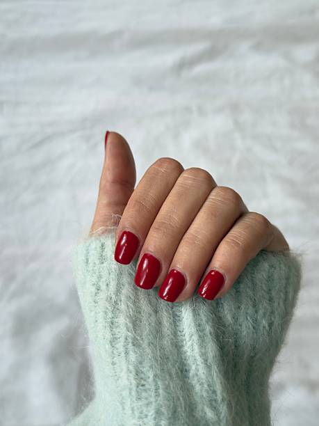 istock Woman showing her freshly done red manicured nails 2250712499