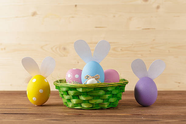 istock Colorful Easter eggs arranged in a green basket on a wooden table setting 2250713130