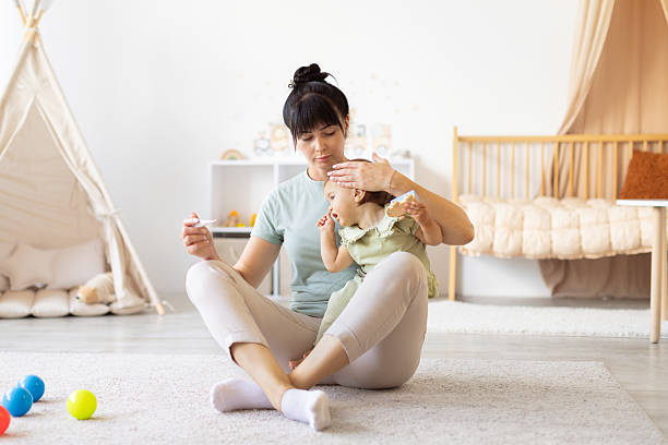 istock Mother checking baby temperature with gentle care while holding thermometer 2250715356