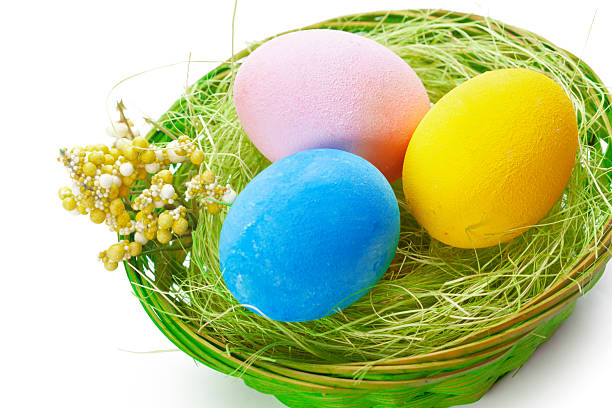 istock Colorful easter eggs arranged in a decorative green nest with flowers on a bright surface 2250716033