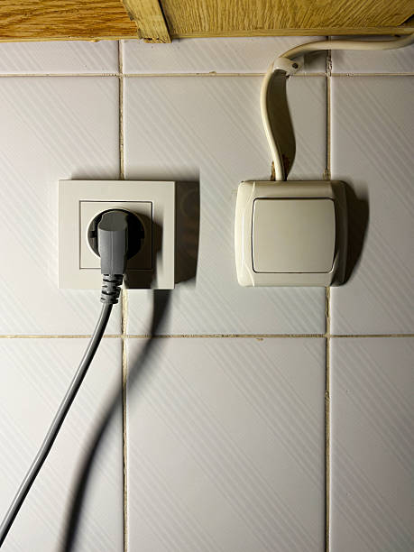 istock Electrical outlet, electric plug and light switch on the ceramics tile wall 2250716667