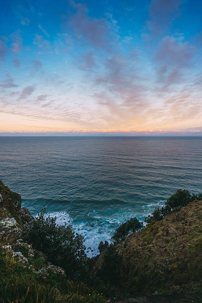 istock Ocean waves crashing below cliff at sunset 2250716679