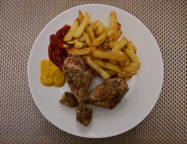 Golden fries and seasoned chicken served with ketchup and mustard on plate.. High quality photo
