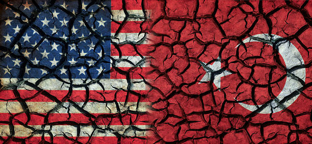 A conceptual image showing the United States and Turkey flags merged on a cracked, distressed surface. The fractured texture symbolizes political tension, diplomatic challenges, fragile relations, and shifting geopolitical dynamics between the two nations.