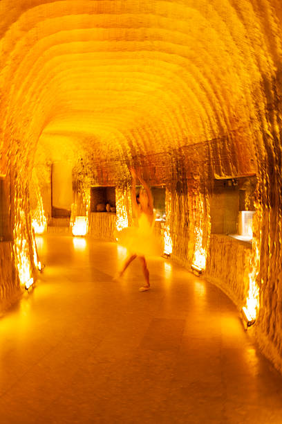 A dreamy, abstract motion-blur photograph of a ballet dancer performing in a warm, golden-lit underground space. The dynamic zoom effect creates a sense of energy, fluid movement and artistic expression. Ideal for themes of creativity, performing arts, dance, motion, and atmospheric interiors.