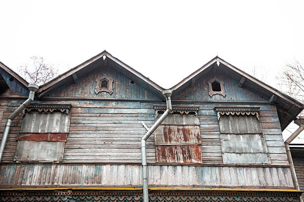 Abandoned wooden facade shows peeling blue timber and weathered textures