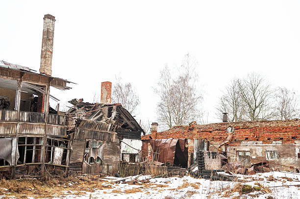 Abandoned ruins with collapsed architecture and crumbling brick in bleak winter landscape