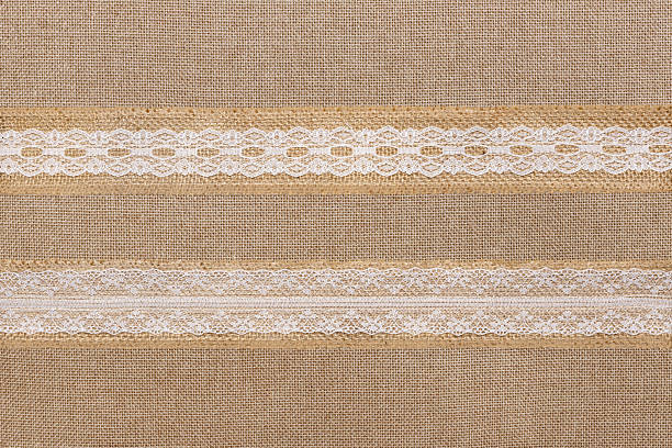 Natural linen background with decorative white lace stripes. Textured vintage style suitable for design, packaging, wedding themes, and craft projects.