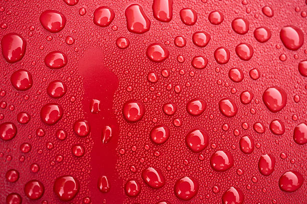 istock Bright red surface adorned with water droplets, showcasing natures beauty in simple yet captivating detail 2250738955