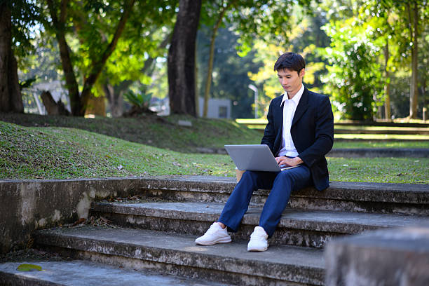 istock A man from an office sits on outdoor steps using a laptop with a calm and focused work mood 2250739058