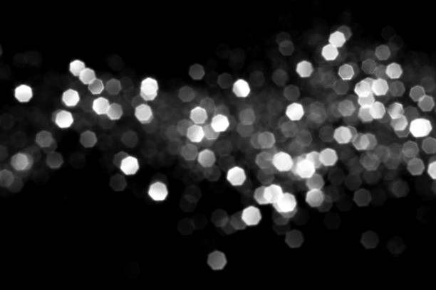 White gray blurred bokeh lights on black background. Glitter sparkle stars for celebrate. Overlay for your design