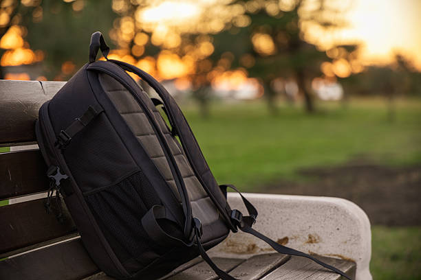 istock Backpack Resting on Park Bench at Sunset in Warm Golden Light 2250740600