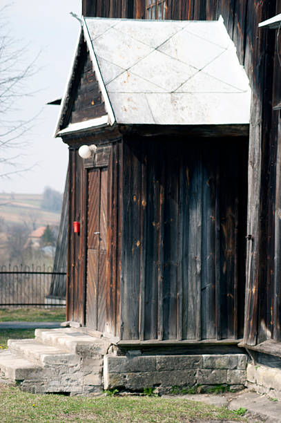 Wooden church. Architectural details. Probołowice, Poland. The wooden parish church of St. James the Apostle from 1759 and the wooden bell tower from the mid-19th century