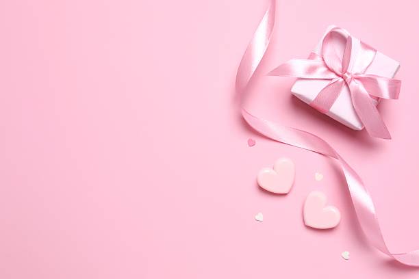 istock Beautiful gift box with pink hearts on color background 2250741580