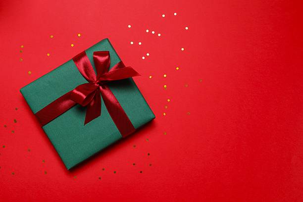 istock Festive gift box with confetti on color background, top view 2250742811