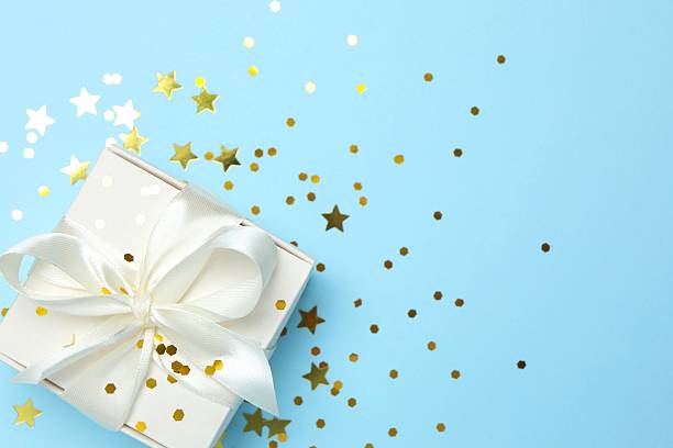 istock Beautiful gift box with confetti on color background, top view 2250744159