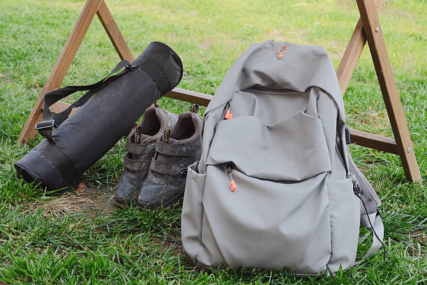 gray backpack, black shoes and bag in green grass . Travel concept