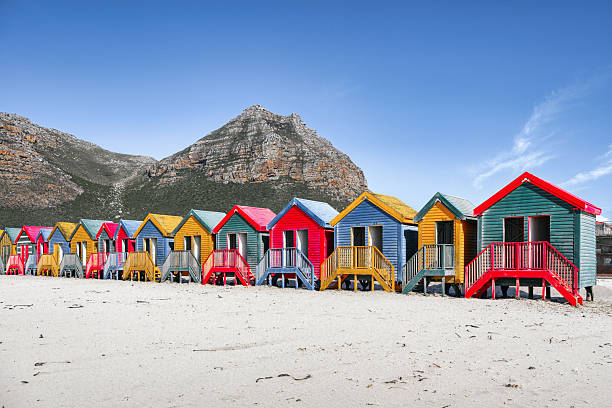colorful beach huts in Muizenberg beach in front of mountain range