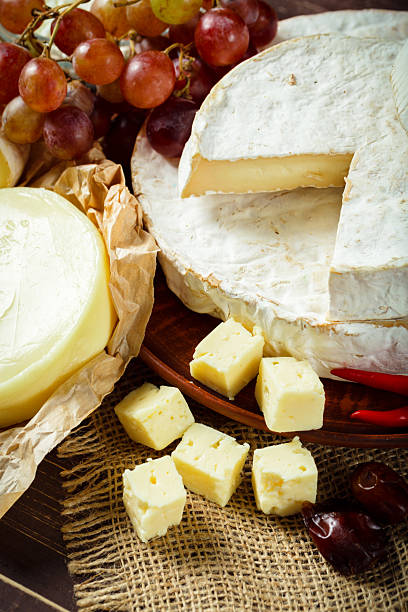 istock Cheese platter with assorted cheeses and fresh fruits on a rustic table 2250754792