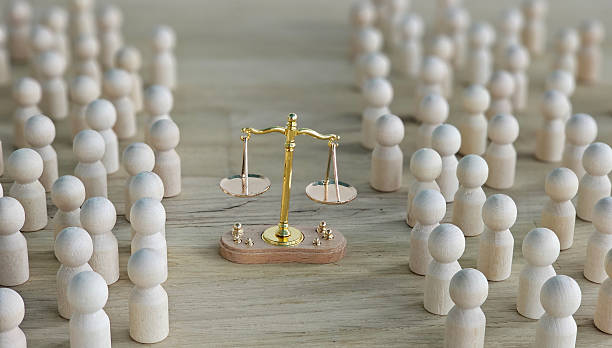 istock Wooden figures surround a balanced scale symbolizing justice in a simple setting with no distractions concept 2250754875