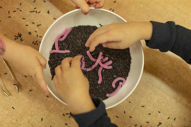 Children engaging in tactile exploration activities, Group of young children examining dark filling with toys