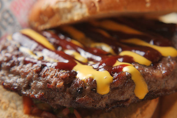 Juicy hamburger with barbecue sauce and mustard on a toasted bun