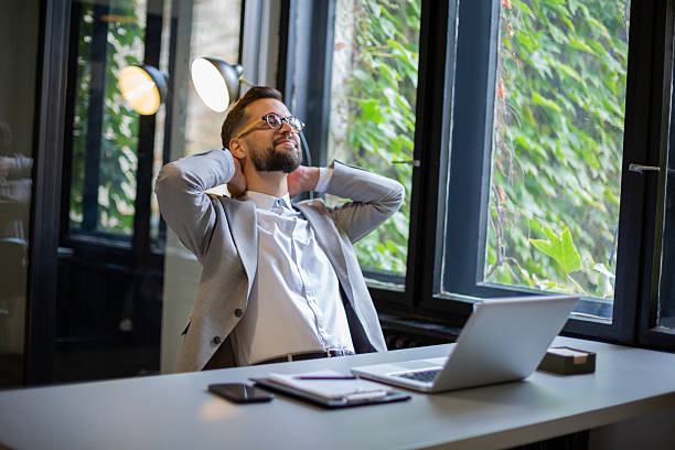 istock Businessman relaxing after work, stretching back at desk 2250756467