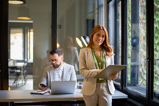 istock Businesswoman standing in office holding folder smiling 2250756826