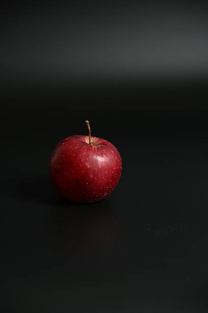 istock Minimalist Still Life: Single Red Apple Isolated on a Black Background 2250757405