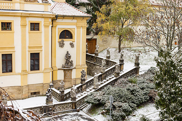 Prague, czech republic - november 24, 2025: baroque staircase and statues dusting with first snow in loreta, prague in hradcany