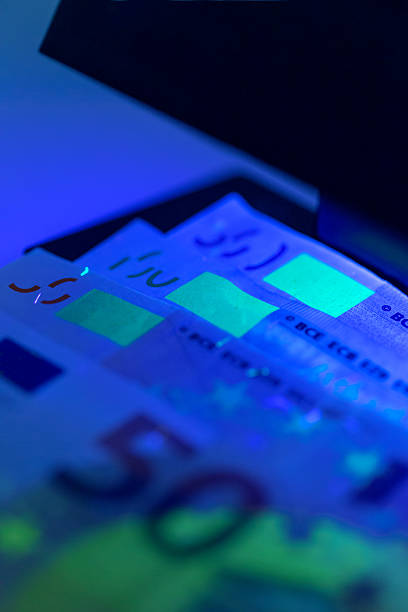 istock Close-up view of illuminated currency under UV light in a dark environment 2250761425