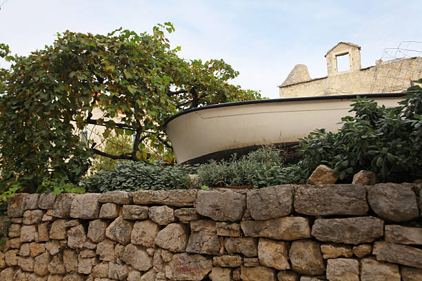 Typical stone wall with boat at courtyard at Dalmatia, Adriatic Sea coast, Croatia