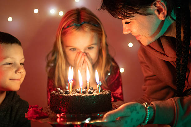 istock Children celebrating birthday, watching lit candles on cake 2250763803