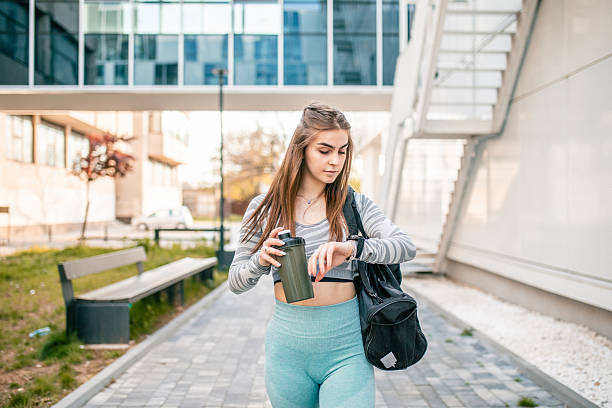 istock Female athlete walks after training, looking at smart watch 2250764809