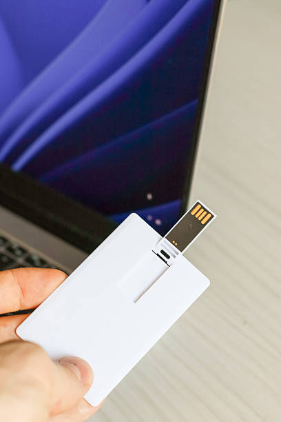 istock Vertical hold of white USB card with extended plug near screen 2250769922