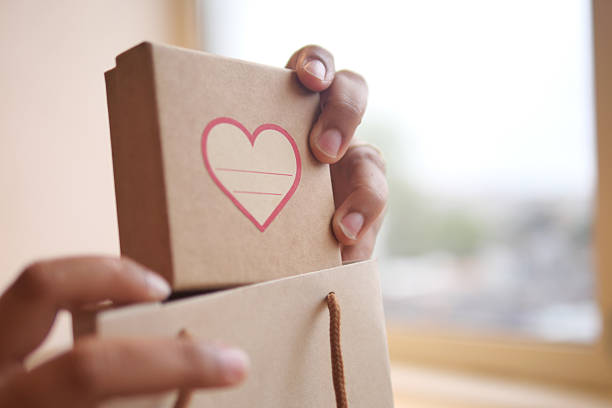 istock Holding a gift box with a heart design in hand 2250770194