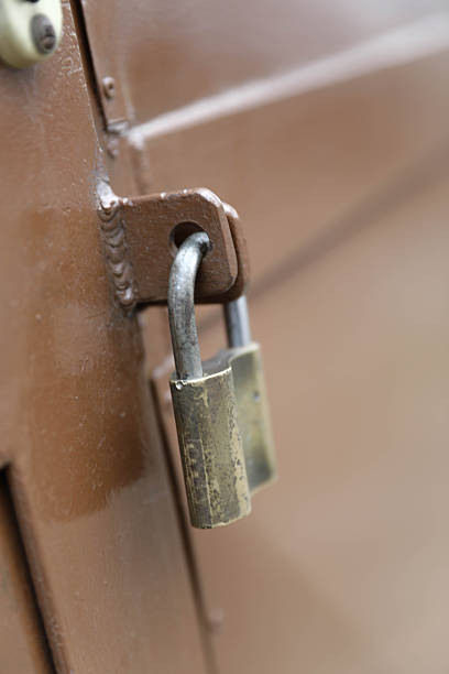 A Close-Up View Of A Padlock Securing A Metal Door, Symbolizing Security, Privacy, Restriction, And Protection In An Urban Environment.