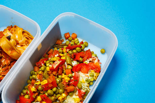 Braised pasta with vegetables in a plastic tray. Lunch for the office worker