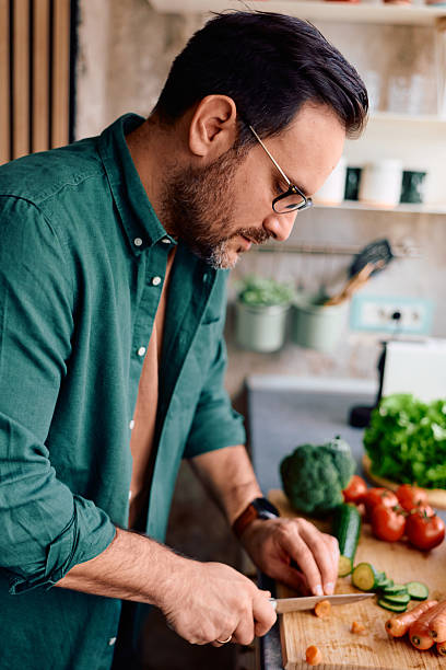 istock Man cooking healthy meal prep chopping vegetables 2250776780