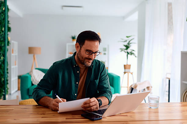 istock Adult man working from home office with laptop and documents 2250777030