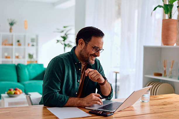 istock Happy man smiling while working from home on laptop 2250777031
