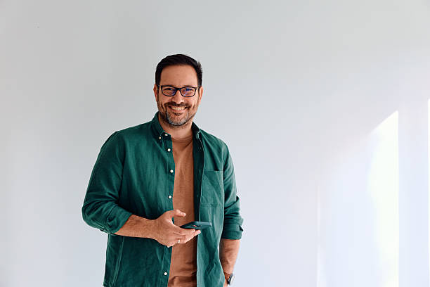 istock Happy man with glasses smiling holding smartphone 2250777310