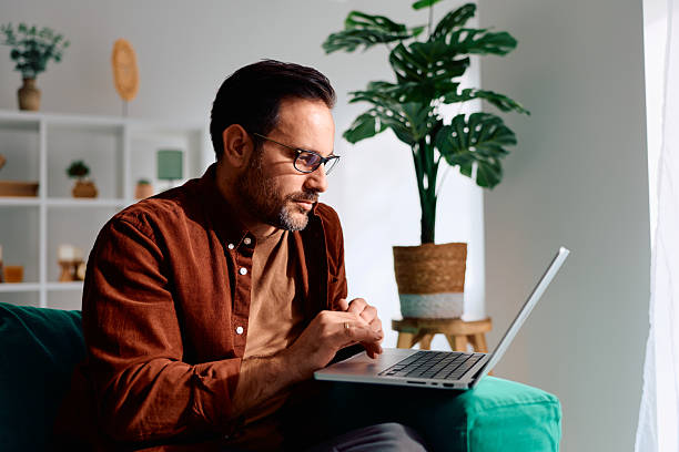 istock Man working from home on laptop from couch 2250777608