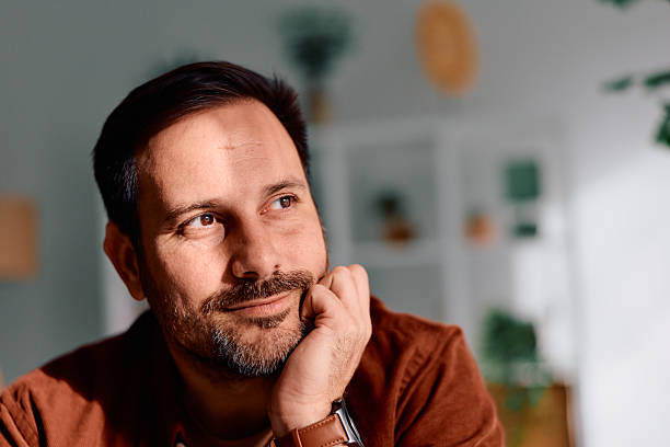 istock Man contemplating, daydreaming with a pensive expression indoors 2250777893