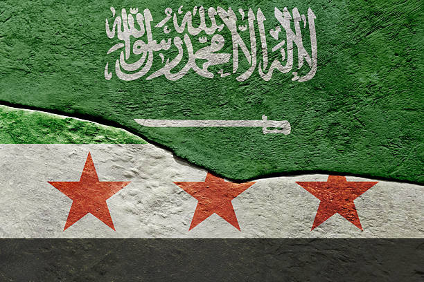 Saudi Arabia and Syria flags painted on a cracked wall symbolizing political separation