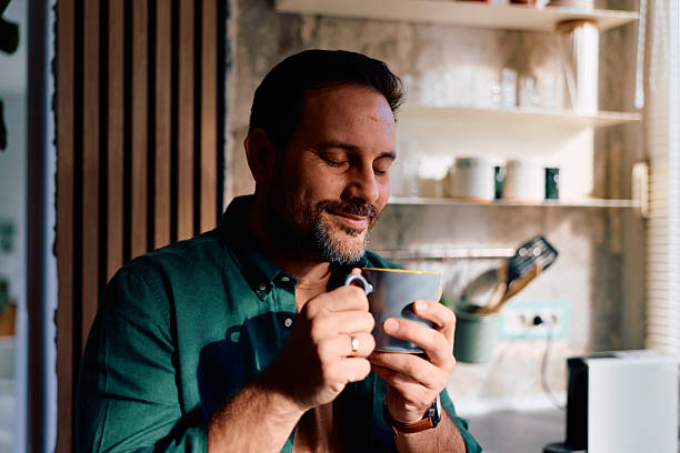 istock Smiling man enjoying morning coffee in kitchen 2250778090