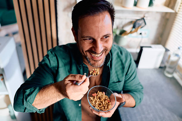 istock Happy man enjoying healthy granola breakfast in kitchen 2250778188