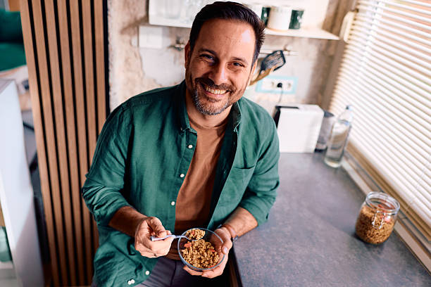 istock Man enjoying healthy granola breakfast in kitchen 2250778278